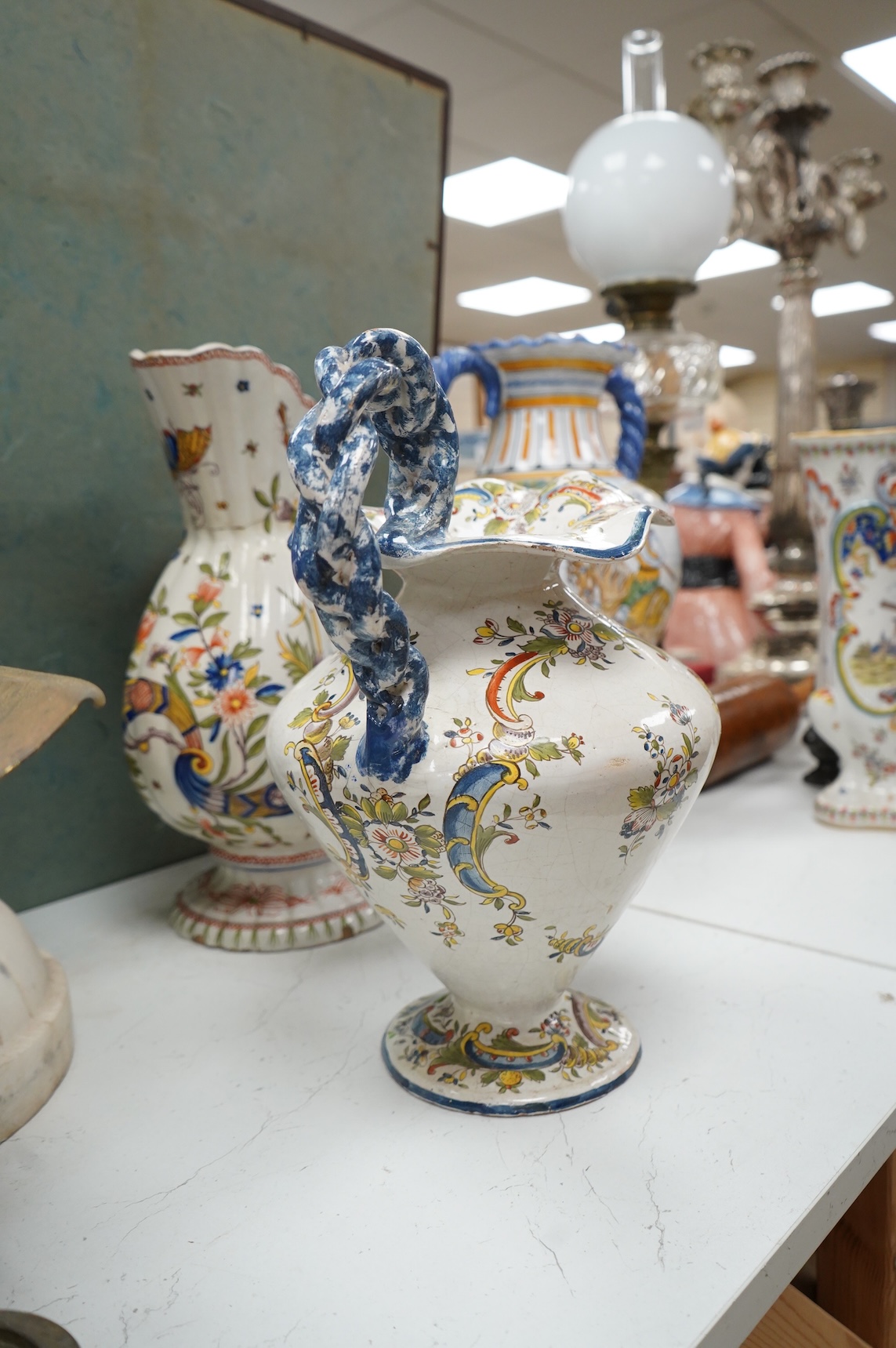 Two large French faience jugs and a vase, and a Talavera twin handled urn/vase, 44cm high